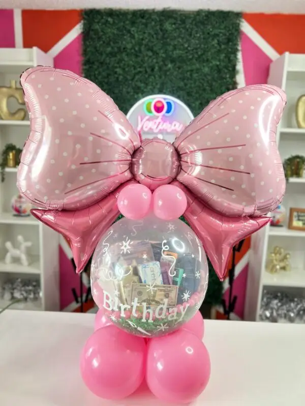 Stuffed balloon gift with clear balloon, blush pink and teal mini balloons, and large decorative bow topper for a birthday celebration.